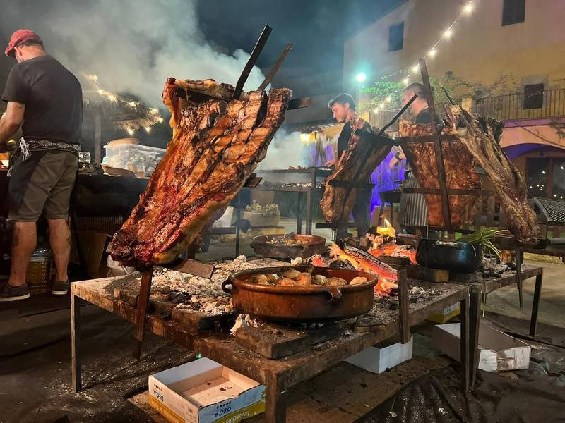 Asado nocturno en un evento con varias cruces de fuego