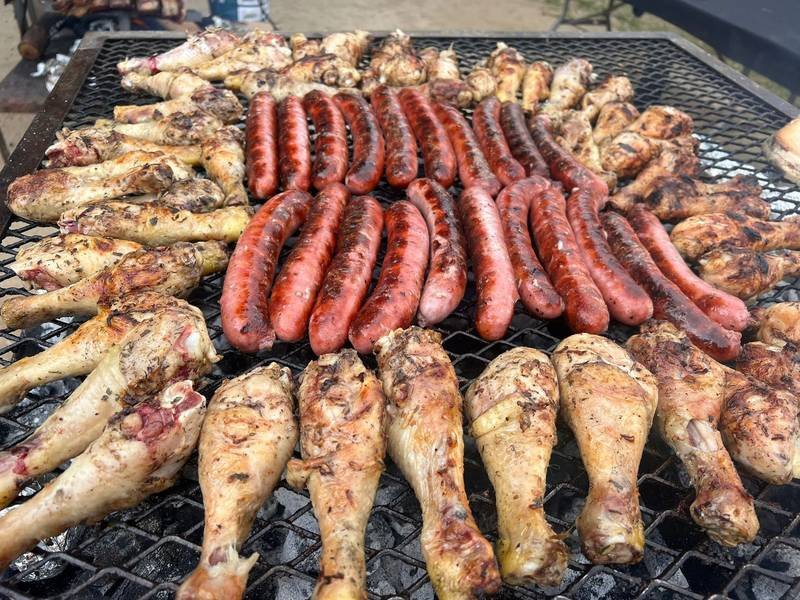Chorizos y muslos de pollo sobre la parrilla