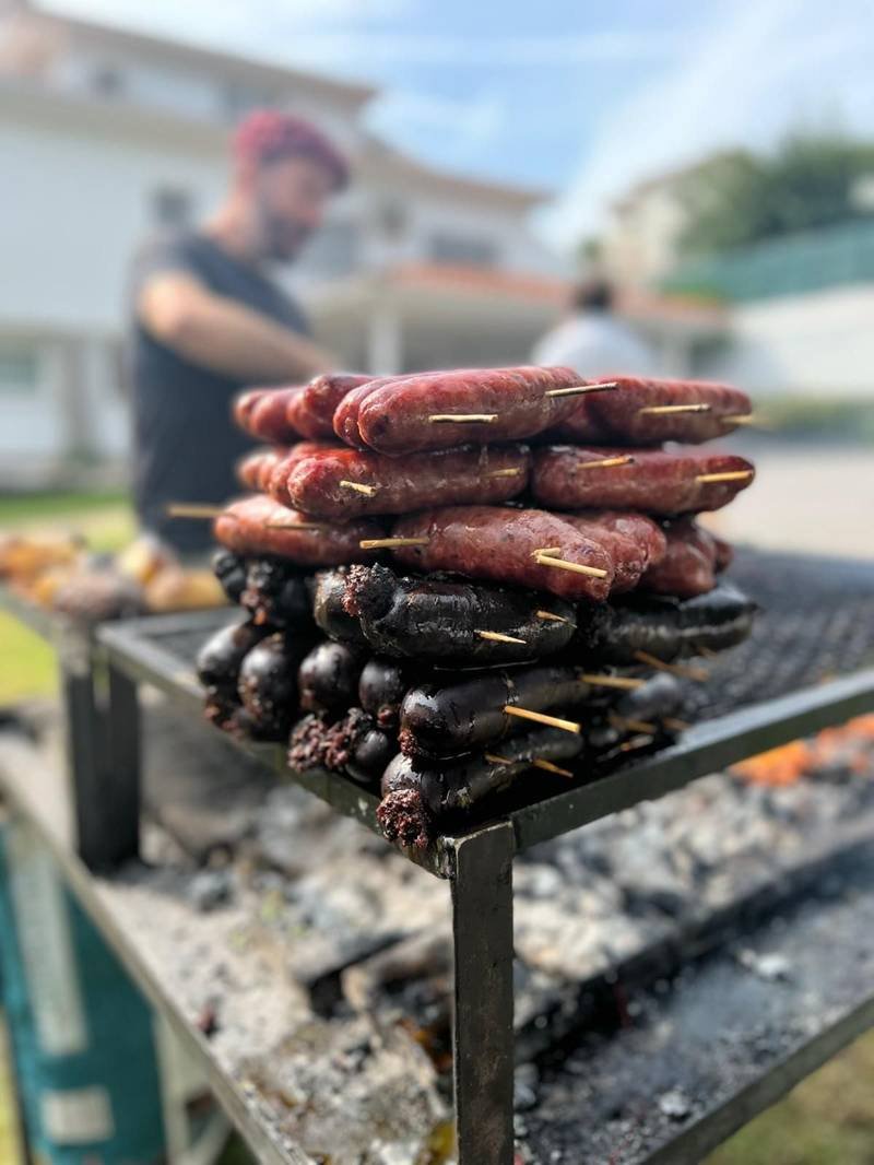 Pinchos de morcilla y chorizo apilados sobre la parrilla